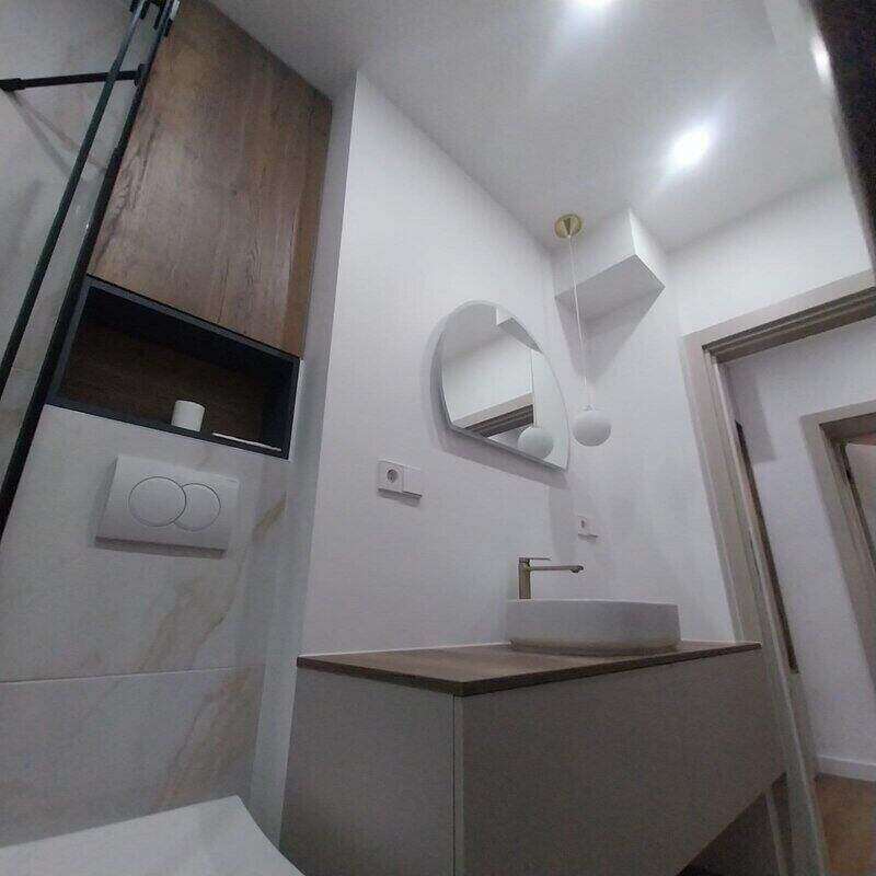 Ogledalo iznad komode sa lavaboom i viseći orman u kupatilu